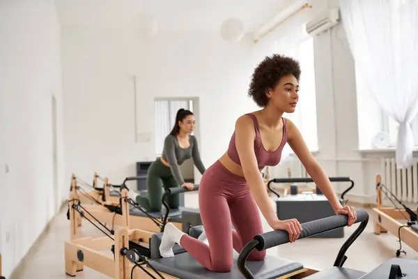 Woman in pink top exercising together with her friend. — Stock Photo