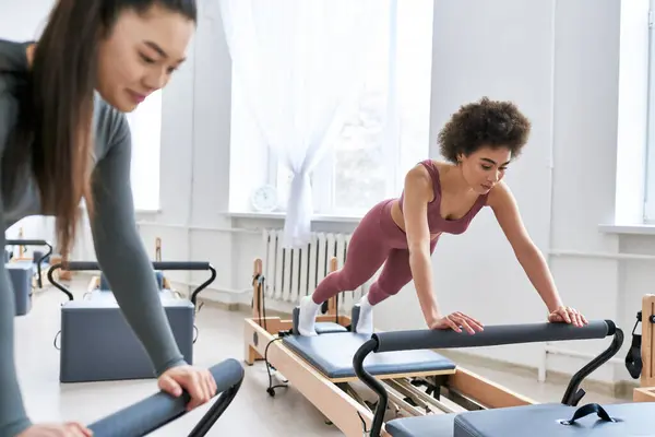 Attractive woman is intensively exercising next to her friend. — Stock Photo