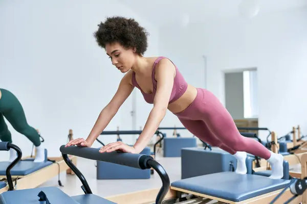 African american woman is intensively exercising next to her friend. — Stock Photo