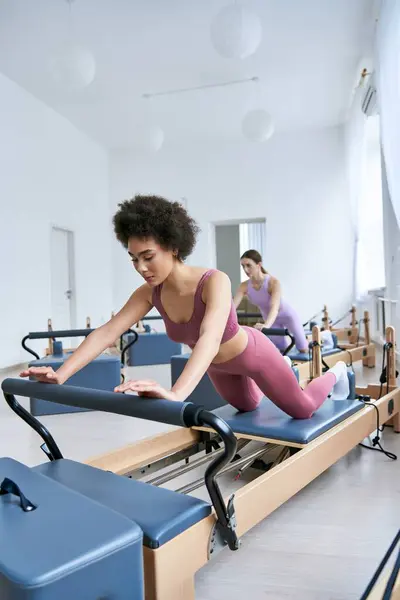 Mujer atractiva haciendo ejercicio hábilmente al lado de su amigo. - foto de stock