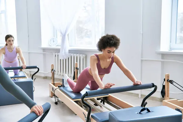 Mulheres de diversas origens realizando exercícios de Pilates em um ambiente de grupo. — Fotografia de Stock