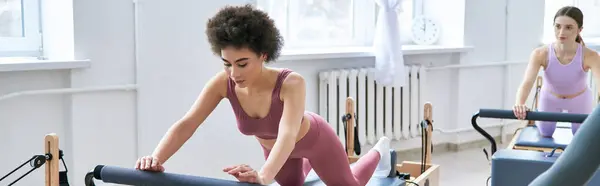 Femme en débardeur rose et leggings effectue des exercices, à côté de son ami. — Photo de stock