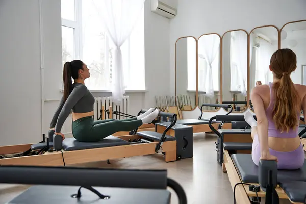 Diverse group of women showcasing balance and strength during a pilates session. — Stock Photo