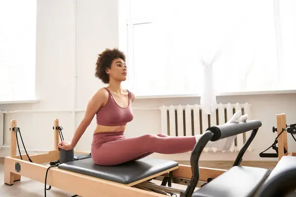 Uma mulher em trajes esportivos rosa exercitando. — Fotografia de Stock