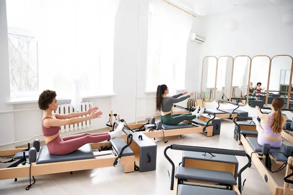 Women engaging in Pilates exercises in a group setting. — Stock Photo
