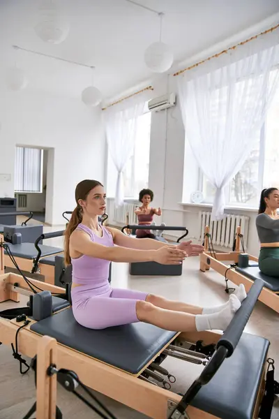 A diverse group of women in a vibrant gym setting, pilates. — Stock Photo