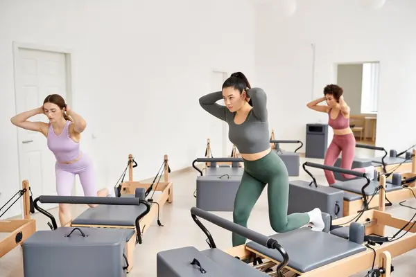 Diverse group of women in synchronized movements during a Pilates session. — Stock Photo