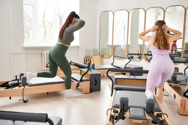 Duas mulheres atraentes se exercitando ativamente, pilates. — Fotografia de Stock