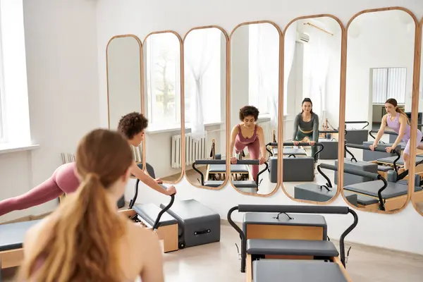 Les femmes sportives s'engagent dans une session de Pilates dans une salle de gym. — Photo de stock