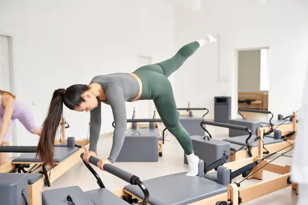 A dynamic group of sporty women engaging in a pilates session in a gym. — Stock Photo
