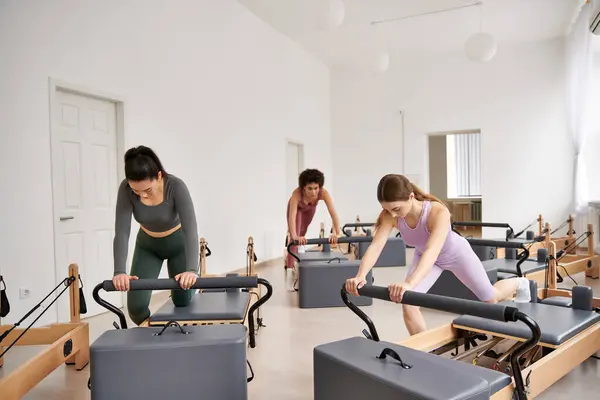 Eine Gruppe stylischer, sportlicher Frauen beim gemeinsamen Training während einer dynamischen Pilates-Einheit. — Stockfoto