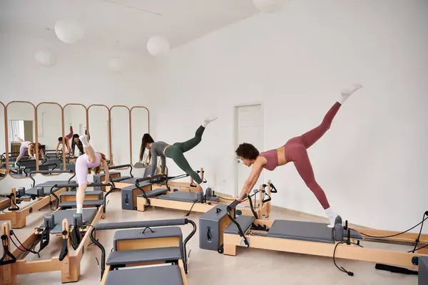 Donne sportive che eseguono esercizi durante una lezione di Pilates in palestra. — Foto stock