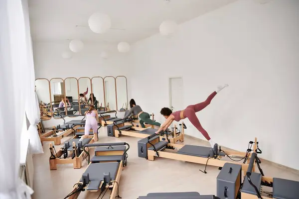 Mujeres atractivas participan en una sesión de Pilates en un gimnasio. - foto de stock