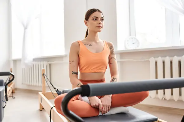 Uma mulher graciosamente senta-se durante uma aula de Pilates. — Fotografia de Stock