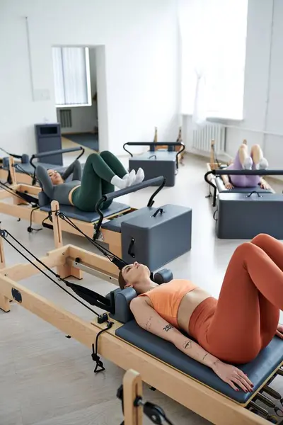 Mujeres deportivas que participan en un entrenamiento de pilates en el gimnasio. - foto de stock