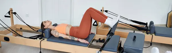 Une jolie femme sportive se couche gracieusement lors d'une leçon de pilates. — Photo de stock