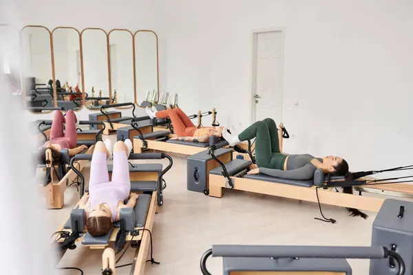 Sportliche Frauen bei einer Pilates-Session in einem lebhaften Raum. — Stockfoto