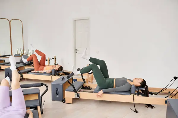 Femmes attrayantes s'engageant dans un entraînement de pilates à la salle de gym. — Photo de stock