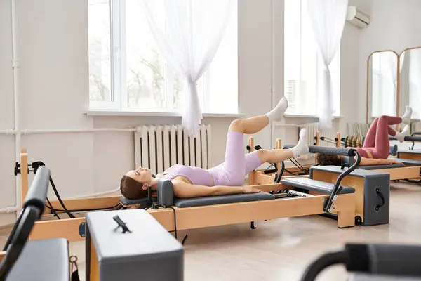 Mujeres guapas practicando pilates en el gimnasio. - foto de stock