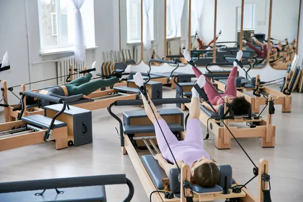 Eine Gruppe ziemlich sportlicher Frauen übt Pilates in einem Fitnessstudio. — Stockfoto