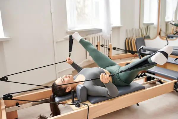 Uma mulher desportiva está a fazer exercício durante uma aula de Pilates. — Fotografia de Stock