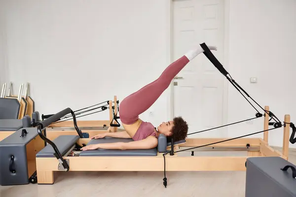 Mulher sedutora graciosamente executa exercícios durante uma aula de pilates. — Fotografia de Stock