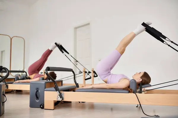Sportliche Frau schwenkt während Pilates-Stunde graziös auf einem Rudergerät. — Stockfoto