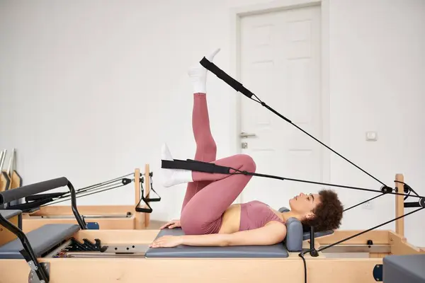 Mulher desportiva em rosa leotard práticas pilates exercícios. — Fotografia de Stock