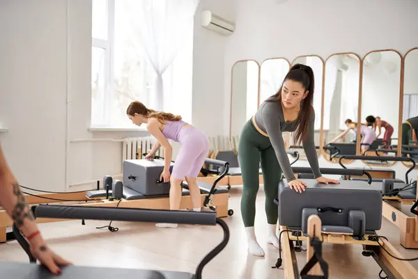 A group of sporty women engaging in a pilates lesson at the gym. — Stock Photo