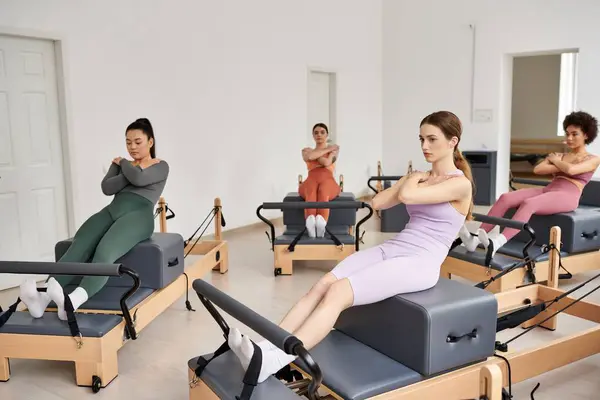 Um grupo vibrante de mulheres muito esportivas envolvidas em uma aula de Pilates em uma sala. — Fotografia de Stock