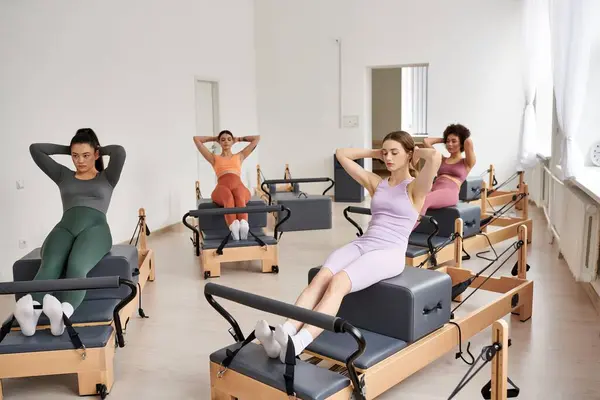 Um grupo de mulheres esportivas praticando pilates em uma sala. — Fotografia de Stock