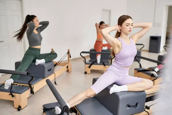 Un grupo de mujeres deportistas ejecutando ejercicios suaves durante una sesión de gimnasio. - foto de stock