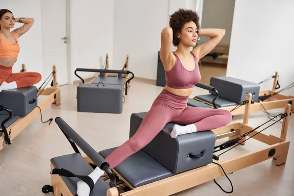 A dynamic group of sporty women engage in a Pilates lesson. — Stock Photo