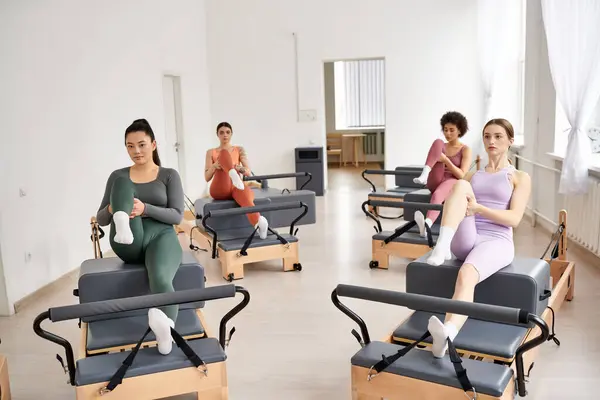 A group of sporty women practicing pilates in a room, sitting in chairs. — Stock Photo