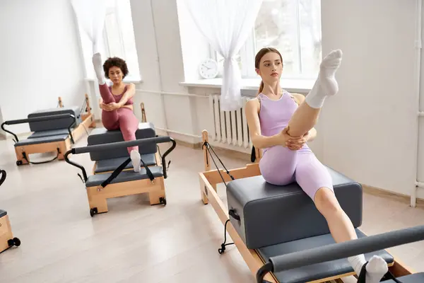 Jolies femmes dans une salle de gym se livrant à une leçon de pilates, en se concentrant sur la force et la flexibilité. — Photo de stock
