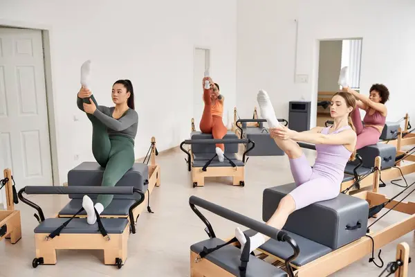 Active women engaged in a Pilates class, focused on stretching and strengthening exercises. — Stock Photo