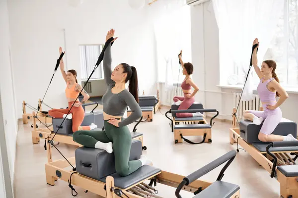 Frauen führen während einer Pilates-Einheit anmutig Übungen aus. — Stockfoto