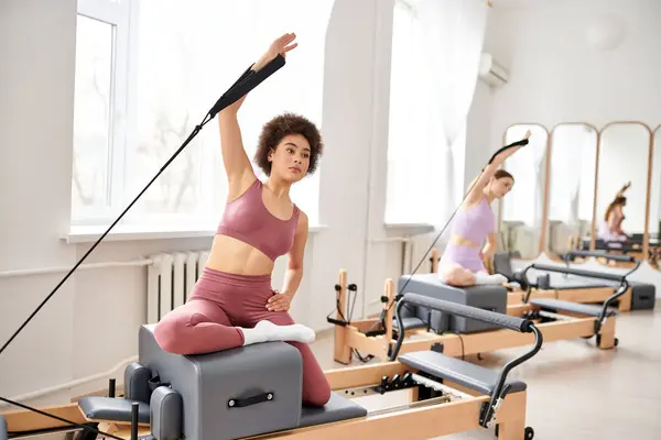 Gut aussehende Frauen nehmen an einem Pilates-Kurs teil, der sich auf Flexibilität und Kernkraft konzentriert. — Stockfoto