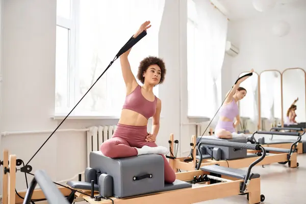 Alluring women engage in a pilates class, focusing on flexibility and core strength. — Stock Photo