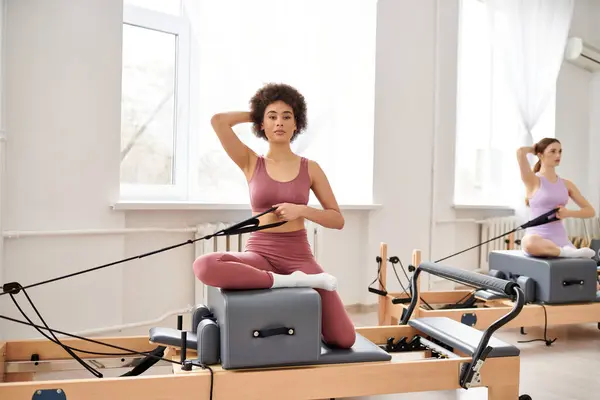 Attraktive Frauen nehmen an einem Pilates-Kurs teil, der sich auf Flexibilität und Kernkraft konzentriert. — Stockfoto