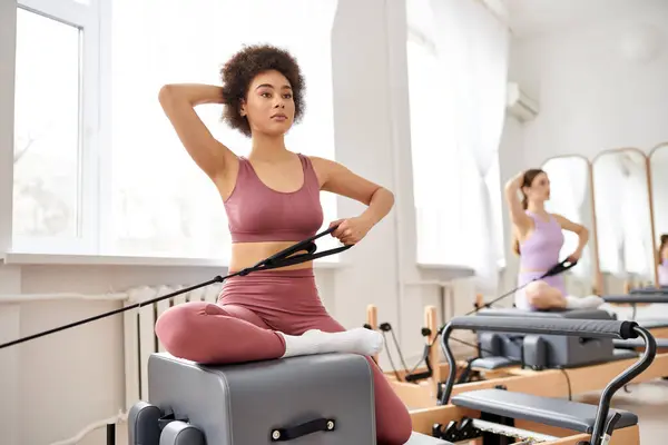 Mulheres bonitas se envolvem em uma aula de pilates, com foco na flexibilidade e força do núcleo. — Fotografia de Stock