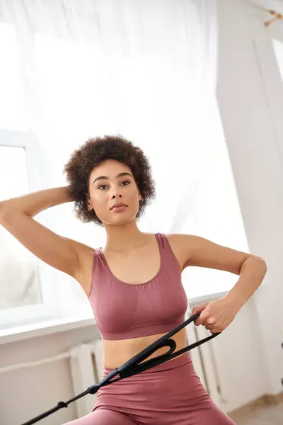 A sporty woman in pink attire performing a pilates exercise. — Stock Photo
