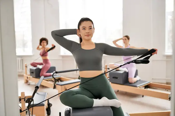 S'adapter les femmes s'engagent dans une classe de pilates, en mettant l'accent sur la flexibilité et la force de base. — Photo de stock