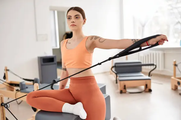 A sporty woman exercises in a gym pilates lesson. — Stock Photo