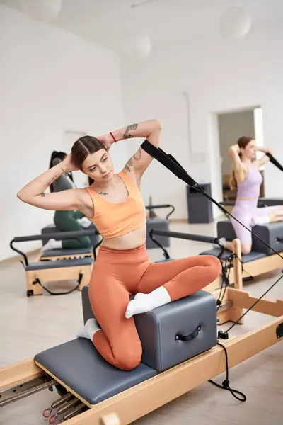Femmes dévouées en vêtements de sport lors de pilates dans une salle de gym ensemble. — Photo de stock