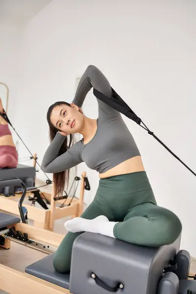 Uma mulher esportiva em um ginásio está realizando exercícios. — Fotografia de Stock