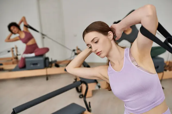 Dedicated women in sportswear during pilates in a gym together. — Stock Photo