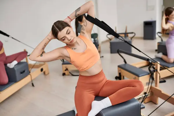 Sporty woman pivots gracefully in pilates class. — Stock Photo