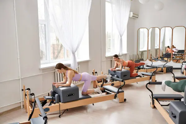A diverse group of fit women exercising in vibrant gym setting. — Stock Photo