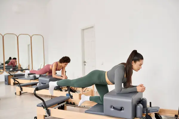 Attraktive Frauen in Sportbekleidung beim gemeinsamen Pilates im Fitnessstudio. — Stockfoto